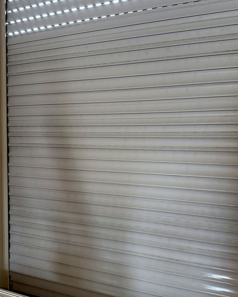 Gereinigter heller Rollladen in einem weißen Fensterrahmen
